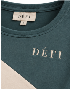 Défi Low Arc women's curved hem T-shirt in dusty teal green and soft ivory, neckline and logo close-up